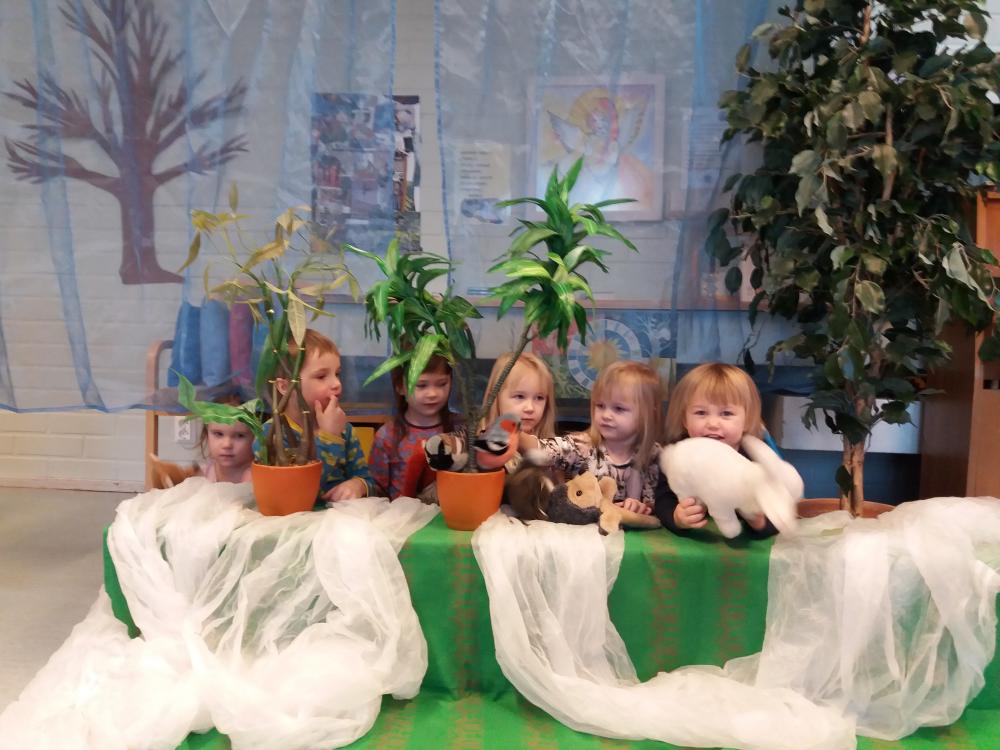 lapset pehmoeläinten kanssa perhekerhosa
valkea kangas vihreän päällä